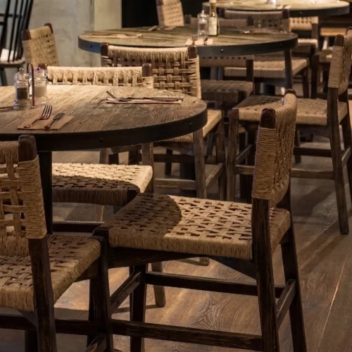 Silla María para Restaurantes, estructura de madera de pino con asiento y respaldo tejido en celulosa natural. Estilo rústico ideal para interiores. Mobiliario ambientado en entorno real gastronómico.